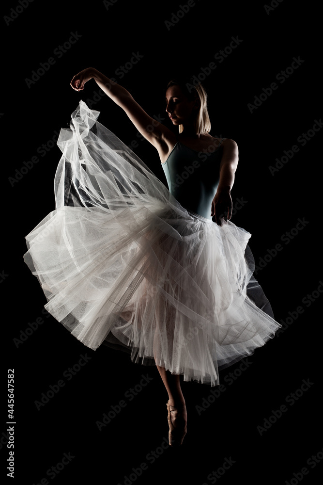 Naklejka premium ballerina with a white dress and black top posing on black background