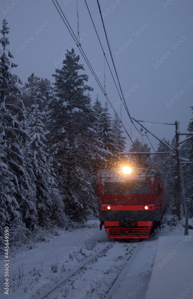 Fototapeta premium The train pulls up to the station alone in the snow