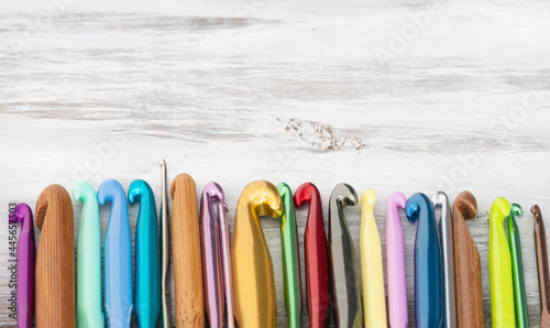 bunch of colorful crochet hook on white wood table 