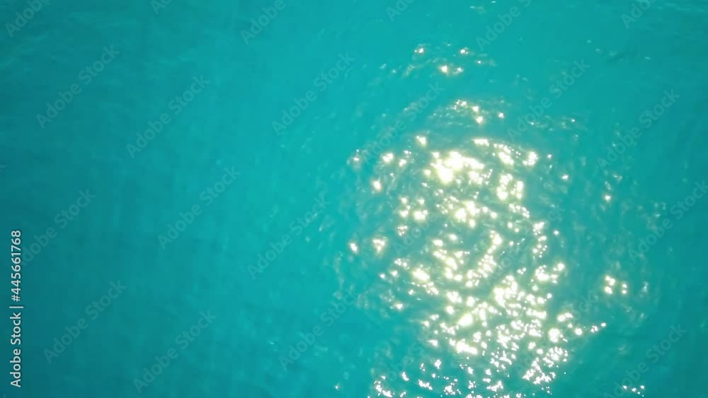 High-angle shot of the azure blue ocean, the golden sunshine falling thereupon, casting a layer of golden gleam onto the surface of water High-angle shot of the azure blue ocean, the golden sunshine falling thereupon, casting a layer of golden gleam onto the surface of water