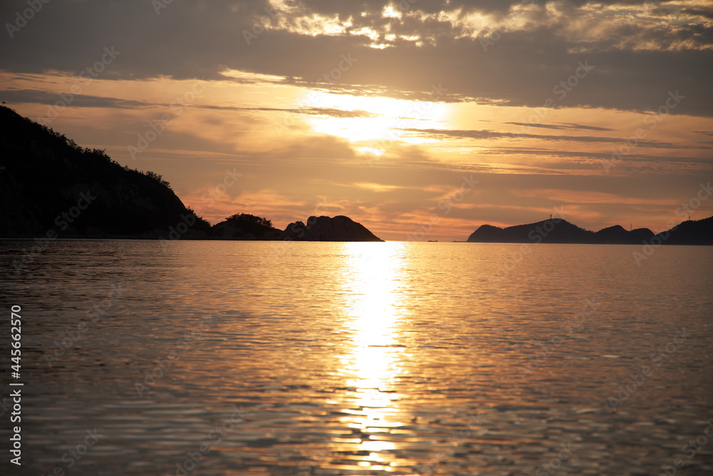 The sunset on a summer day reflected between the small islands and clouds of the Gogunsan Islands in Korea