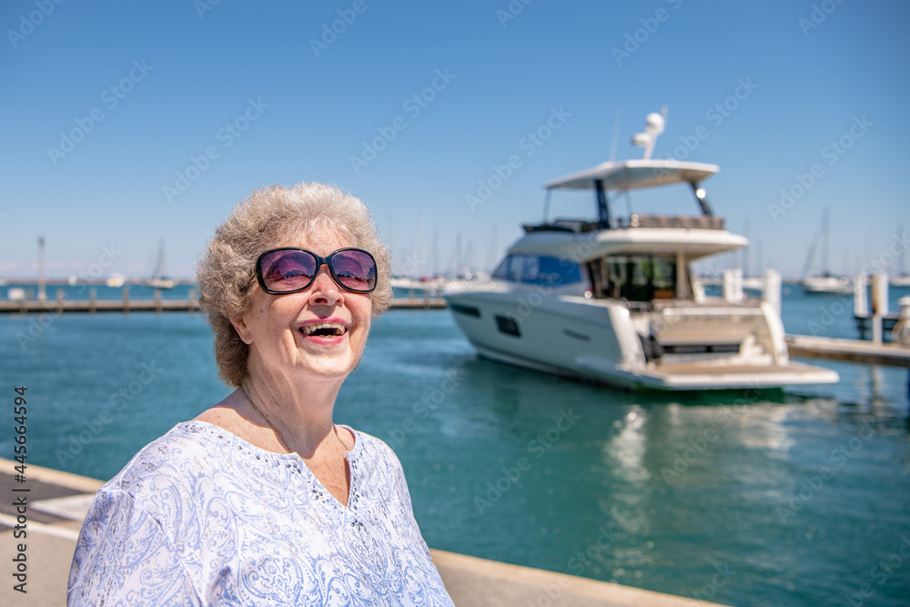 A beautiful senior woman enjoys the day taking a walk by the lake.