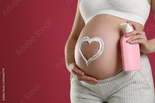Wallpaper Mural Young pregnant woman with cosmetic product on pink background, closeup. Space for text Torontodigital.ca