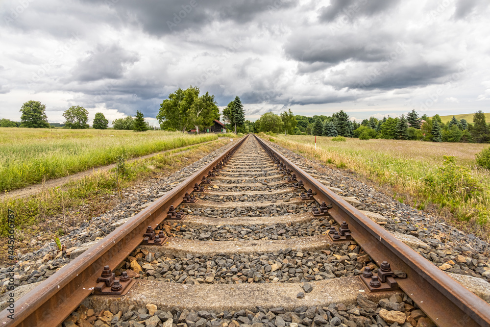 Symmetry railway in summer countryside under cloudy sky Symmetry railway in summer countryside under cloudy sky