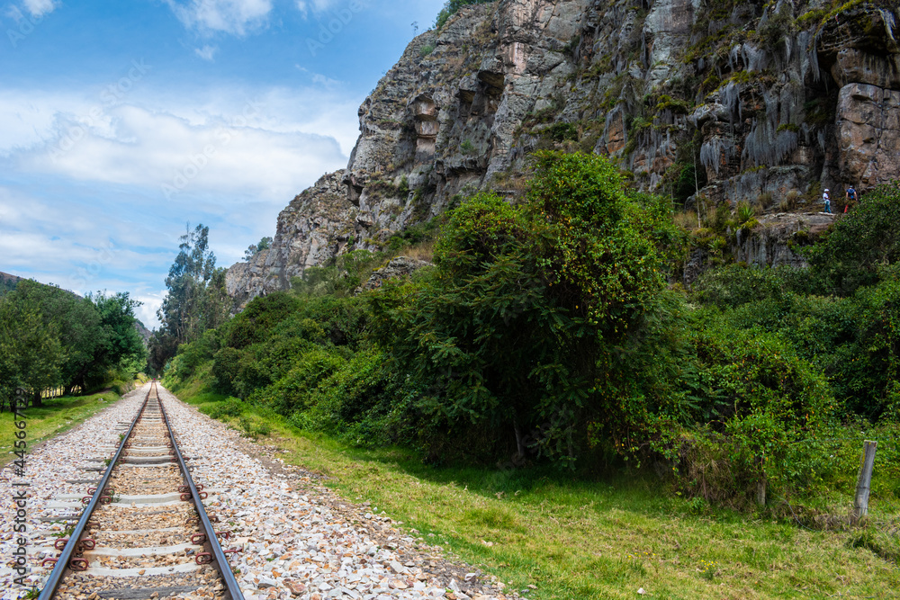 Train tracks that cross steep mountains and green trees in Colombia.