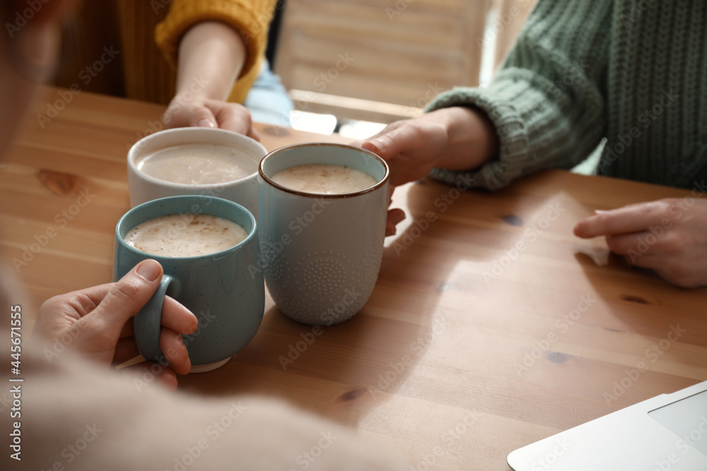 Women with cups of coffee at table in cafe, closeup Women with cups of coffee at table in cafe, closeup