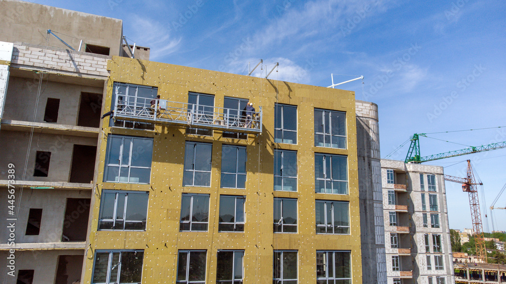 Building external wall thermal insulation with mineral wool. Exterior passive house wall heat insulation with mineral wool. Insulation the facade of commercial building. Energy efficiency