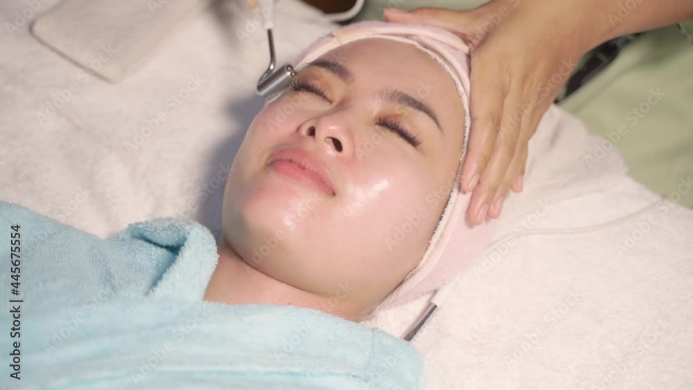 Young woman feel relax having facial treatment by therapist in beauty center Young woman feel relax having facial treatment by therapist in beauty center