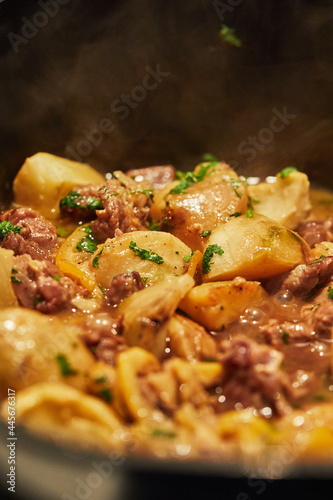 Lamb with lemon, artichokes and coriander stalks are fried over low heat in cauldron