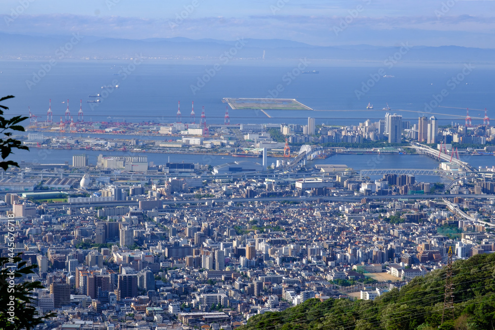 梅雨明けの爽やかな朝、六甲山の中腹七兵衛山より神戸市街、六甲アイランドを望む。遠景は大阪湾と大阪南港が見える