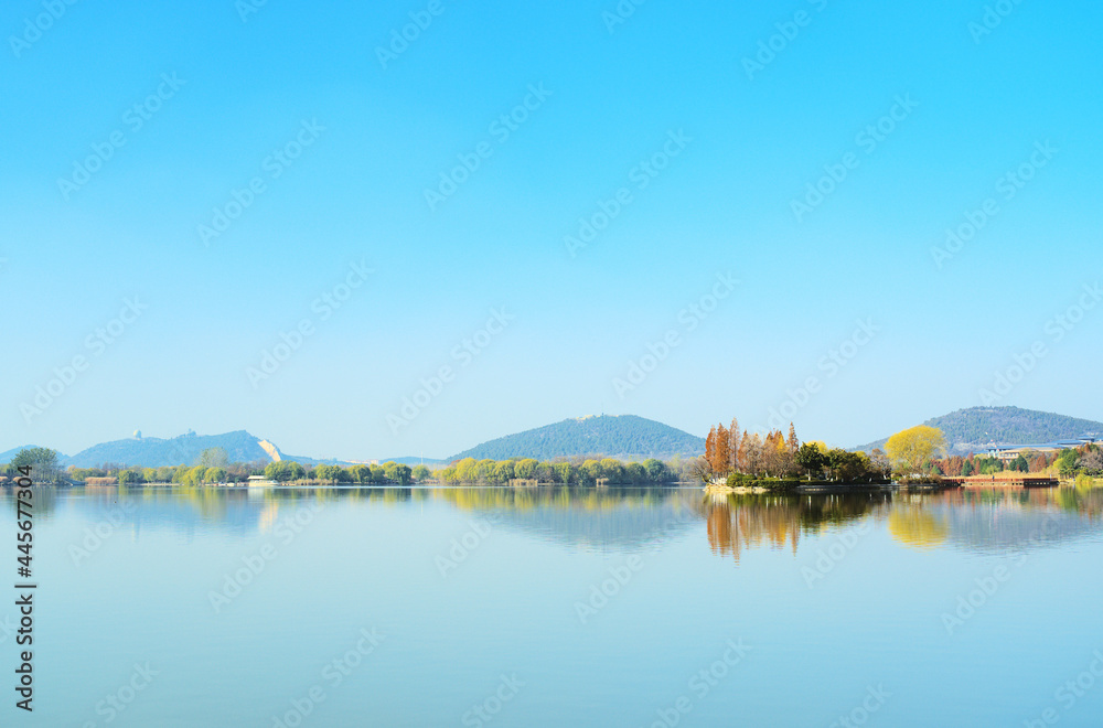 Plants and mountains reflected on clear lake, beautiful natural landscape, panoramic view