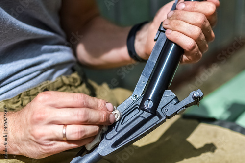Hobbies and outdoor recreation. A man wipes an air rifle with a rag and prepares it for shooting.