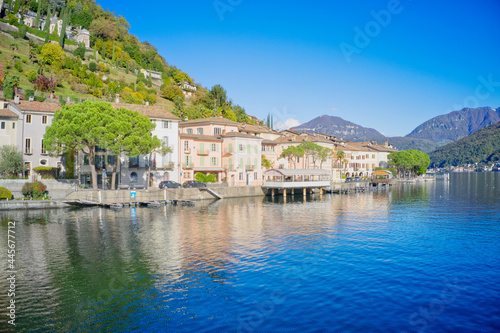 Switzerland, a crystal clear river and buildings at the foot of Alps