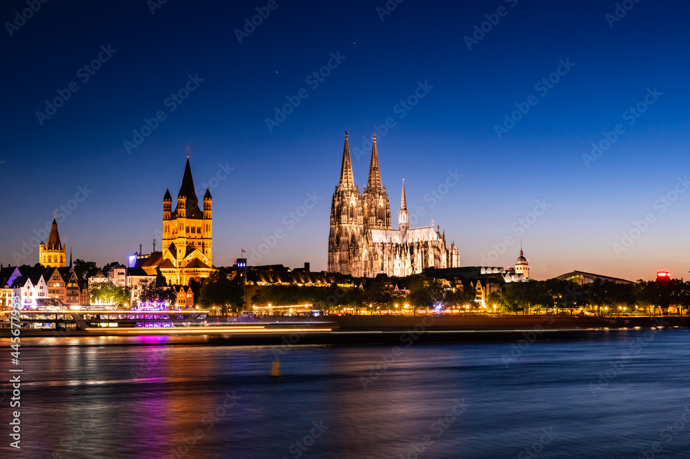 In Cologne, Germany, bright lit at night, the old buildings stand in the center of the city. Long shot