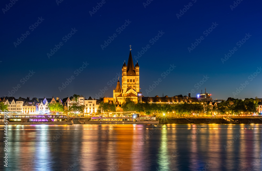 Majestic cathedral in Cologne, Germany, beautiful park by the river, night view of city. Long shot