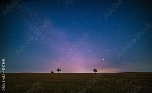 Low angle view of the colorful Milky Way in the starry sky above the fields