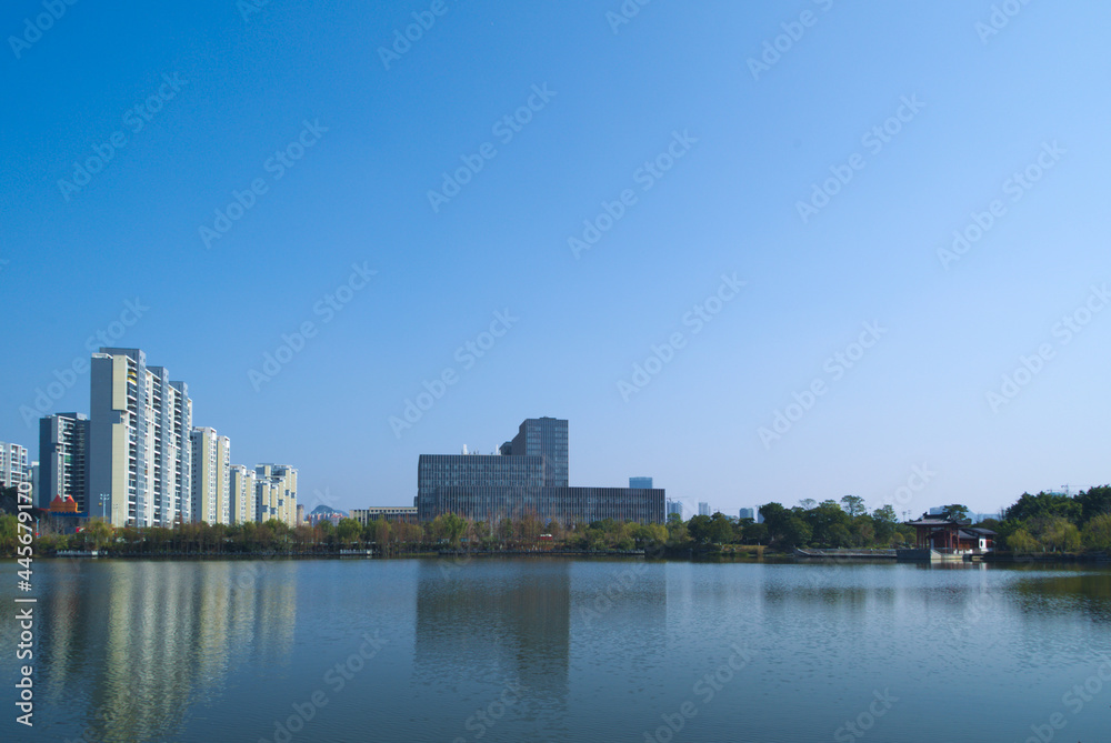 Distant view of tall buildings in a city by the lake under the blue sky
