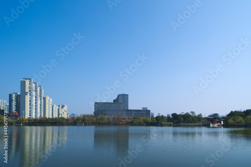 Distant view of tall buildings in a city by the lake under the blue sky © Wheat field