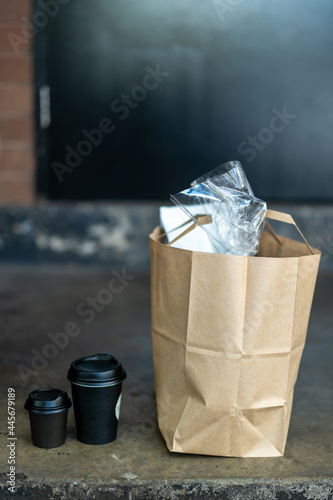 brown paper shopping bag with take away coffees on front porch of house