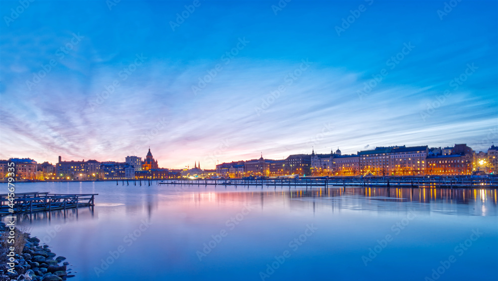 Beautiful night view of a city in Finland with the blue lake and sky