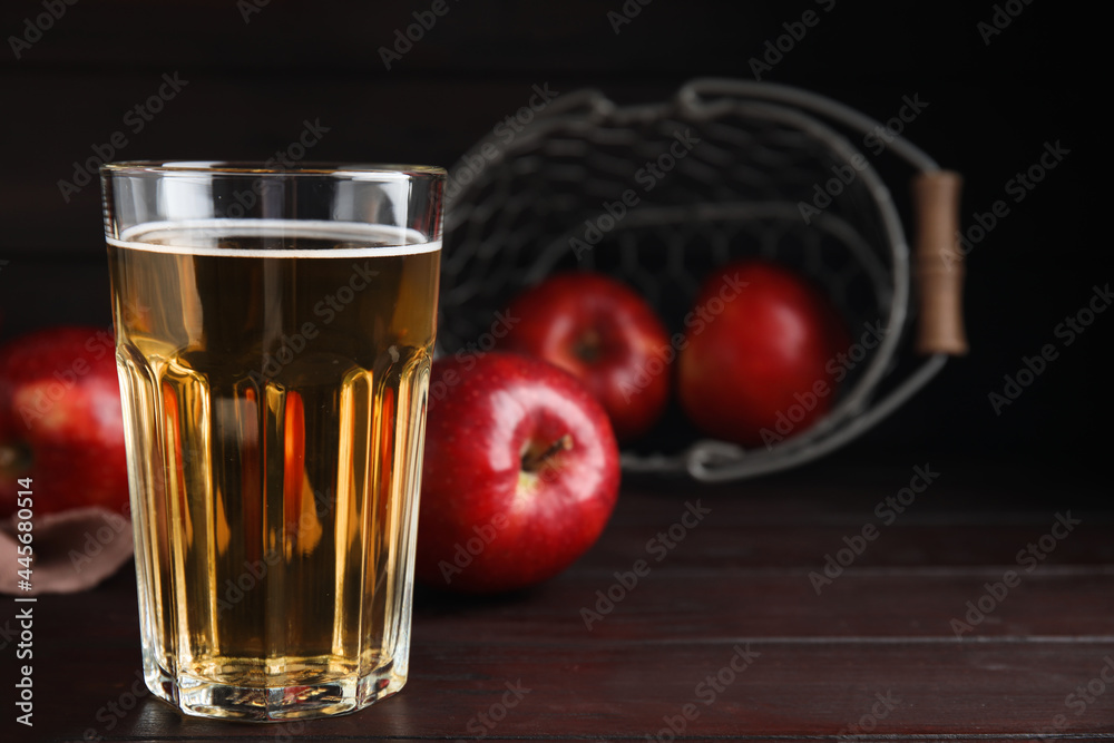 Glass of delicious cider and ripe red apples on wooden table. Space for text Glass of delicious cider and ripe red apples on wooden table. Space for text