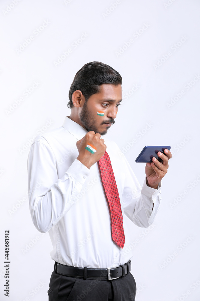 young indian man giving shocking expression after seeing smartphone. young indian man giving shocking expression after seeing smartphone.
