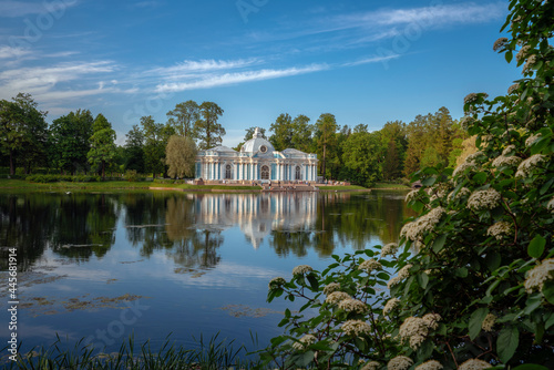Pavilion Grotto on the shore of a large pond in the Catherine Park in Tsarskoye Selo on a sunny summer evening. Pushkin, St. Petersburg. Russia