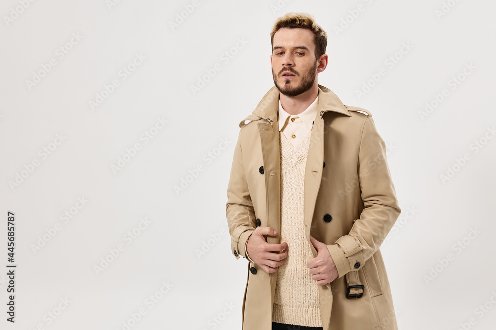 a man with a fashionable hairstyle holding onto a coat fashion Studio Copy Space a man with a fashionable hairstyle holding onto a coat fashion Studio Copy Space