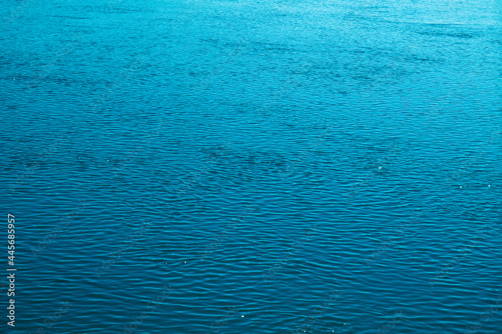 Blue water background. The calm surface of the sea. Ocean. Natural abstract background. Film grain and noise. Blue water background. The calm surface of the sea. Ocean. Natural abstract background. Film grain and noise.