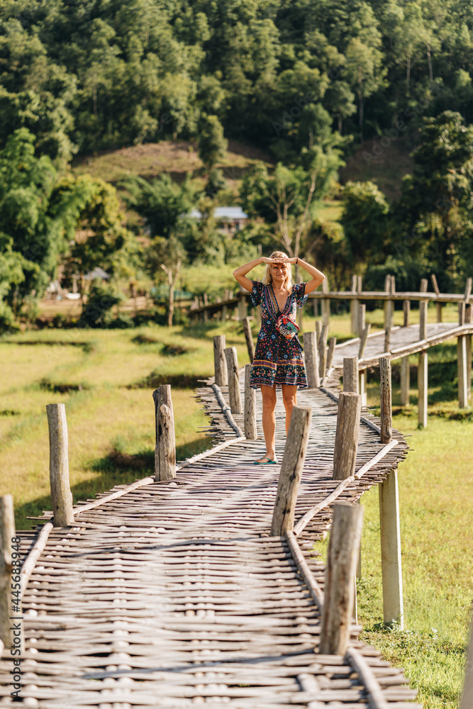 Tourist woman walking at Bamboo bridge over rice paddies, Boon Ko Ku Soo in Pai