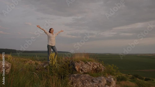 Girl raises her hands up and cherfully smiling photo