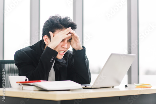 Wallpaper Mural Stressed Asian businessman working with laptop in modern office. Young executive being angry about financial situation. Torontodigital.ca