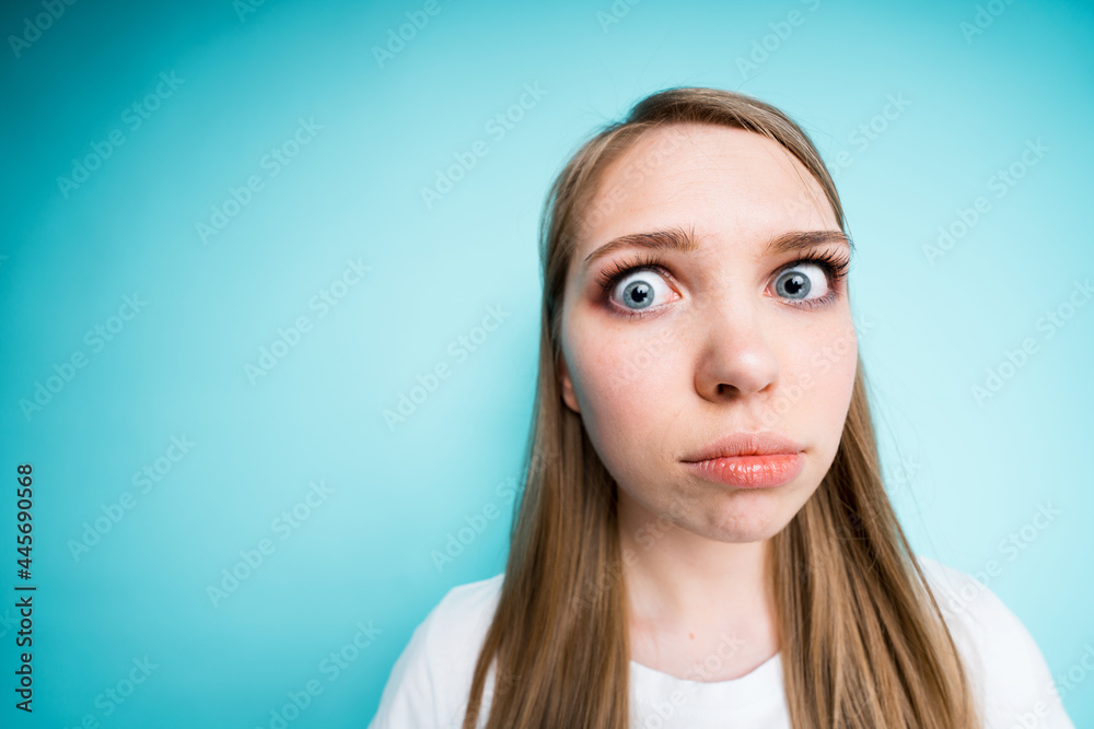 Beautiful frightened girl in a white t-shirt looks sadly at the camera with her lips protruding Beautiful frightened girl in a white t-shirt looks sadly at the camera with her lips protruding