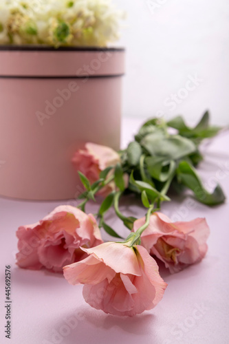 Vertical image of pink present box, beautiful eustoma flowers on the bright pink surface