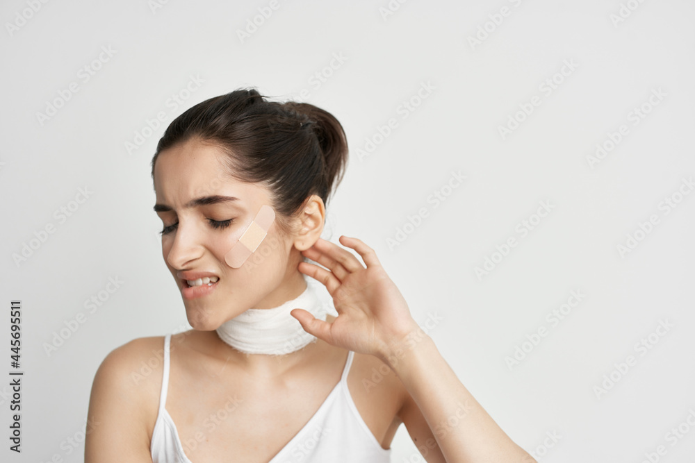 woman in white t-shirt bandage on the neck light background woman in white t-shirt bandage on the neck light background
