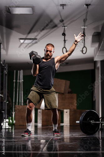 Muscular athlete lifting very heavy weights. Man working out indoors.