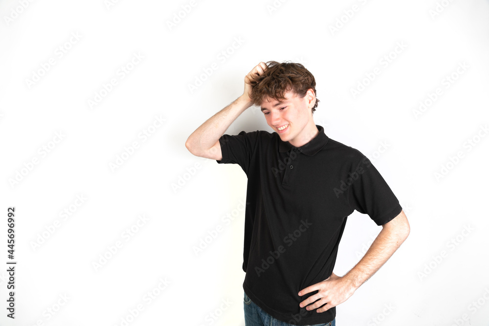 Portrait of a worried guy with his hand in the head looking down, white background, 18-20 years old. White european guy. Portrait of a worried guy with his hand in the head looking down, white background, 18-20 years old. White european guy.