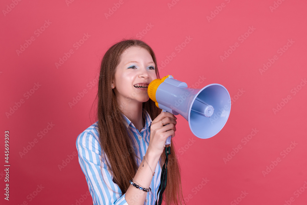 Little kid girl 13 years old in blue dress with brackets isolated on pink background shouting in megaphone happy positive cheerful Little kid girl 13 years old in blue dress with brackets isolated on pink background shouting in megaphone happy positive cheerful