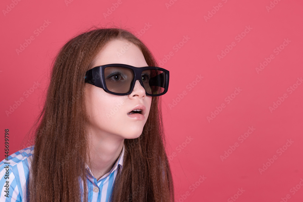 Little kid girl 13 years old in blue dress with brackets isolated on pink background wearing 3d cinema glasses shocked look right Little kid girl 13 years old in blue dress with brackets isolated on pink background wearing 3d cinema glasses shocked look right
