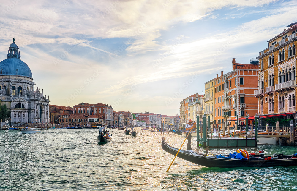Romantic view of Grand Canal, Venice, Italy. Basilica di Santa Maria della Salute or St Mary of Health, colorful palaces by waterfront, many gondolas