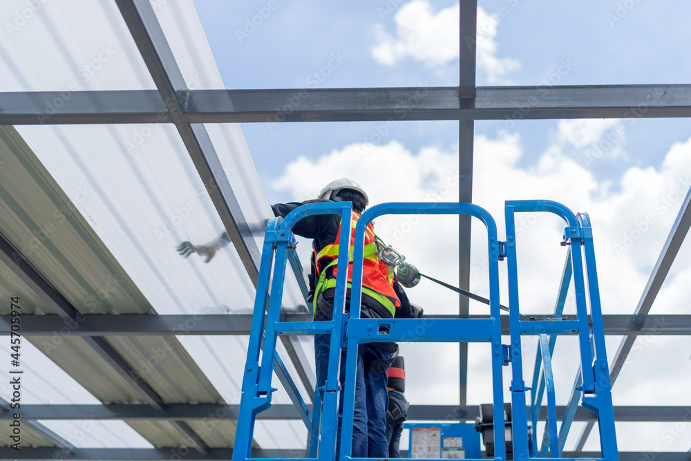 Image showcasing Workers on a Scissor Lift Platform working safety at hight for install ...