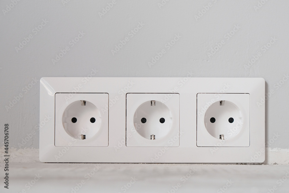 White electrical outlets with frame on gray wall background White electrical outlets with frame on gray wall background