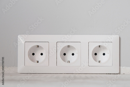 White electrical outlets with frame on gray wall background