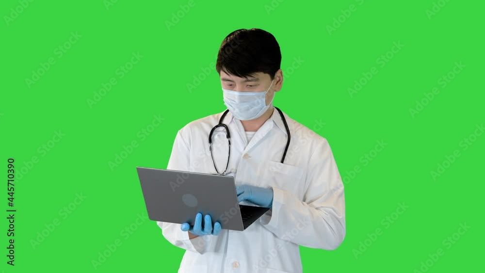 Young asian doctor is working on laptop, searching and typing on a Green Screen, Chroma Key. Young asian doctor is working on laptop, searching and typing on a Green Screen, Chroma Key.