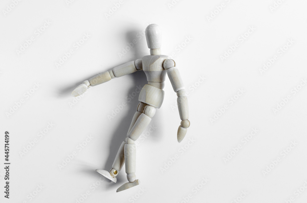 Abstract figure of a wooden man lying on a light background. The figure of a wooden man on a light background close-up Abstract figure of a wooden man lying on a light background. The figure of a wooden man on a light background close-up