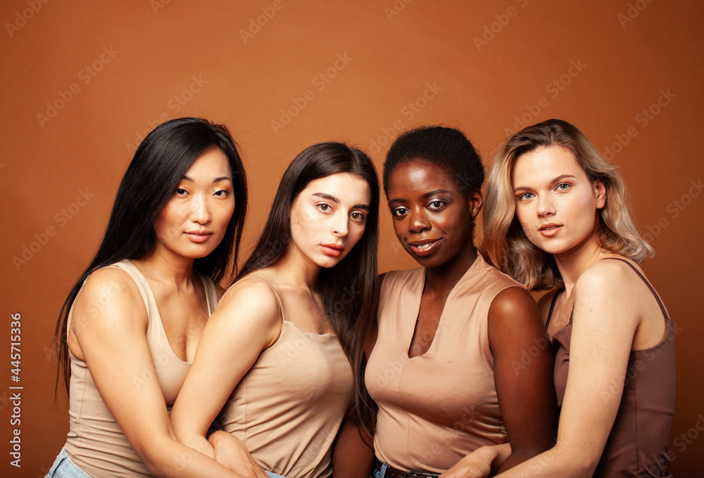 Obraz premium young pretty asian, caucasian, afro woman posing cheerful together on brown background, lifestyle diverse nationality people concept