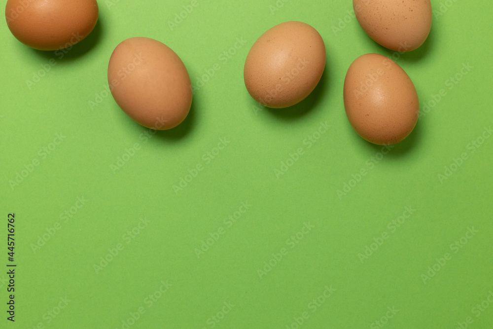 Easter brown chicken eggs on a green background