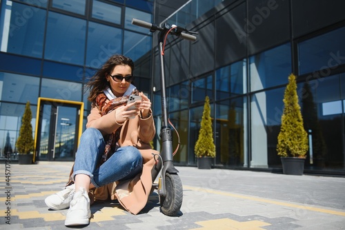 Young beautiful woman riding an electric scooter to work, modern girl, new generation, electric transport, ecology, ecological transport, sunset, electric skateboard.