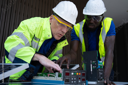 solar power plant engineers and examining photovoltaic panels. Concept of alternative energy and its service. Electrical and instrument technician.