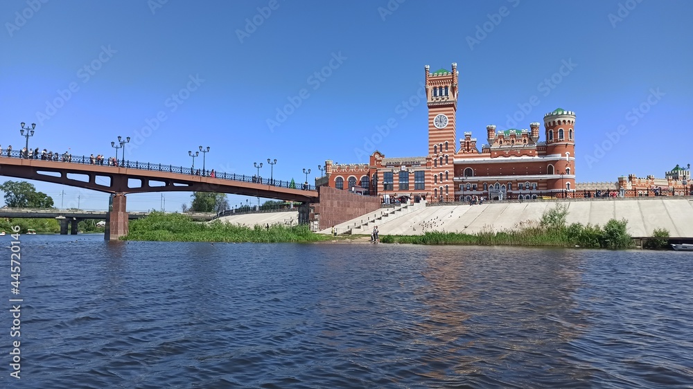 Bridge with a beautiful red tower and clock in the Republic of Meri El, in the city of Yoshkar-Ola in Russia. July 16, 2021